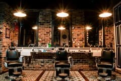 Salon de barbier chaleureux avec fauteuils et mur de briques