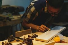Artisan menuisier travaillant le bois avec ses outils dans son atelier